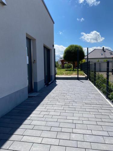 a brick walkway next to a white building at Moderne Wohnung in Heskem bei Marburg (Lahn) 