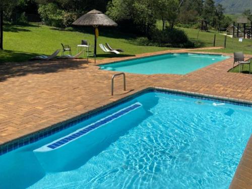 a large swimming pool with blue water in a yard at Champagne Lane Resort in Champagne Valley