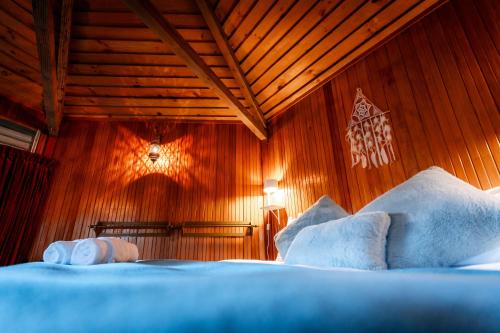 a bedroom with wooden walls and a bed with pillows at Ora Retreat in Queenstown