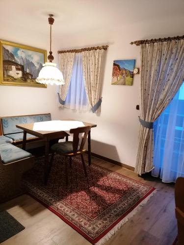 a dining room with a table and a rug at Der Sonnenhof - Ferienwohnungen in Obermaiselstein