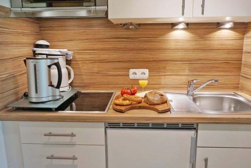 a kitchen counter with a coffee maker and a plate of food at Der Sonnenhof - Ferienwohnungen in Obermaiselstein