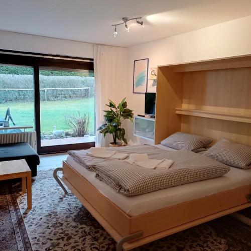 a bedroom with a large bed and a large window at Der Sonnenhof - Ferienwohnungen in Obermaiselstein