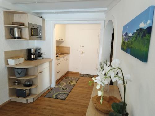 a kitchen with white cabinets and a vase of flowers at Der Sonnenhof - Ferienwohnungen in Obermaiselstein