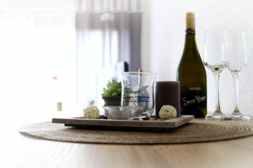 a table with a bottle of wine and wine glasses at Der Sonnenhof - Ferienwohnungen in Obermaiselstein