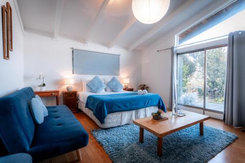 a bedroom with a blue bed and a blue couch at Ora Retreat in Queenstown