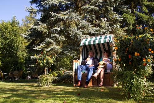 a man and woman sitting in a porch swing at Hotel Jägerhof in Staatsbad Brückenau