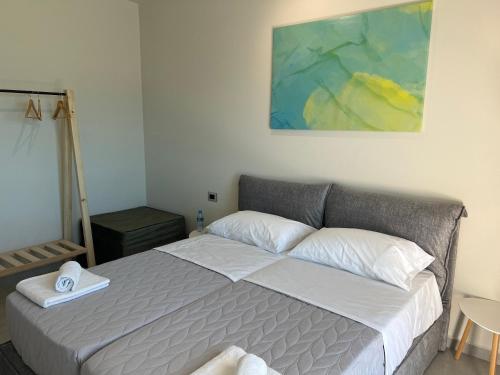 a bedroom with a bed and a painting on the wall at STAY-FIVE rooms & apartments in Shkodër