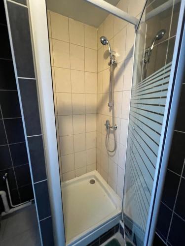 une douche avec une porte vitrée dans une salle de bain dans l'établissement Studio st Quentin centre, à Saint-Quentin