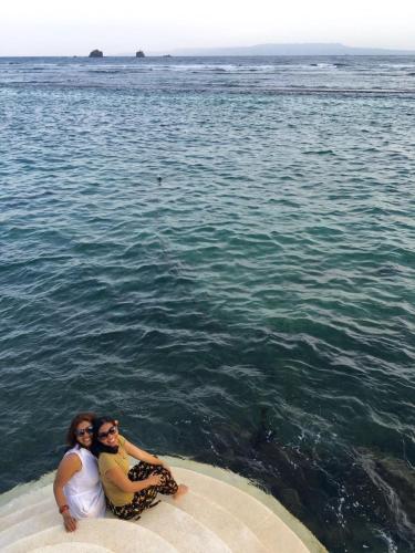 two people sitting on the edge of the water at Villa Kaniksa in Candidasa