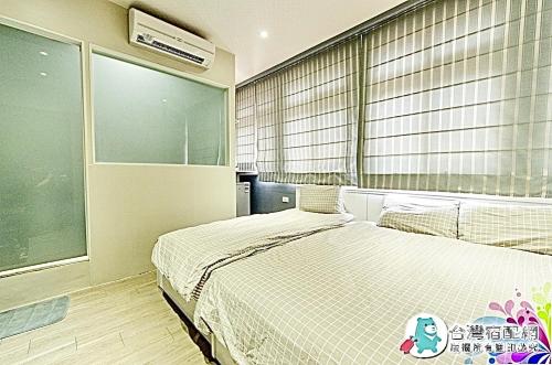 a bedroom with a bed and a large window at 鬆宿民宿 in Luodong