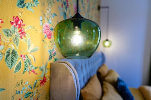 a person holding a glass lamp on a wall at Villa Magnolia Wissembourg in Wissembourg