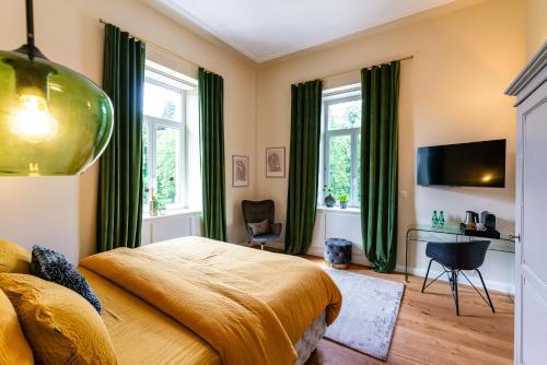 a bedroom with a large bed with green curtains at Villa Magnolia Wissembourg in Wissembourg