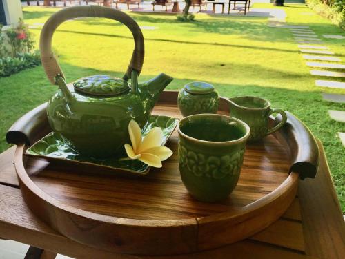 a tea pot and cups on a wooden table at Villa Kaniksa in Candidasa