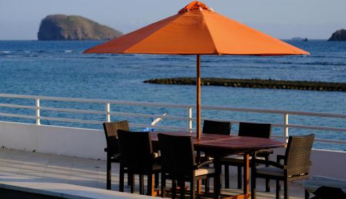 a table with chairs and an orange umbrella on a boat at Villa Kaniksa in Candidasa
