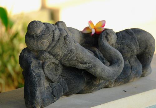 an elephant statue sitting on a table with a flower at Villa Kaniksa in Candidasa