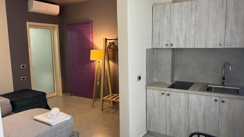 a kitchen with a sink and a room with a bed at STAY-FIVE rooms & apartments in Shkodër
