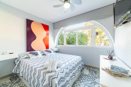 un dormitorio con una cama y una ventana en Las Buganvillas, en Roquetas de Mar