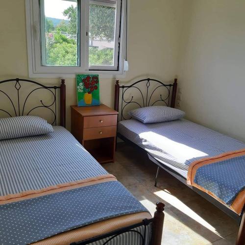 MARE-By the sea في Frangoulaíika: غرفة نوم بها سريرين ونافذة