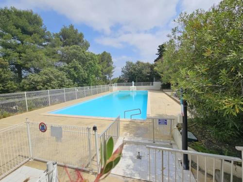 une grande piscine bleue à côté d'une clôture dans l'établissement Havre de paix en famille !, à Coursan