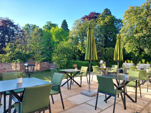 a patio with tables and chairs and umbrellas at Villa Magnolia Wissembourg in Wissembourg