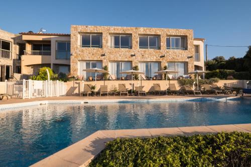 une piscine devant un immeuble dans l'établissement Hôtel Funtana Marina, à LʼÎle-Rousse