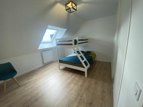 a small room with a bunk bed in a attic at L oeillet Blanc - Maison familiale in Quiberon