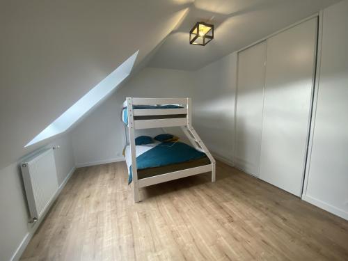 a bunk bed in a small room with a ladder at L oeillet Blanc - Maison familiale in Quiberon