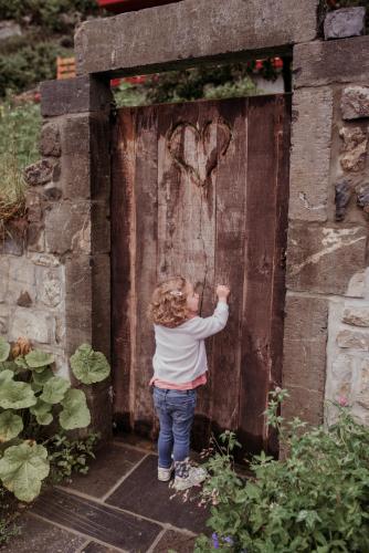 a little girl standing in front of a wooden door at La grotte Dinant in Dinant