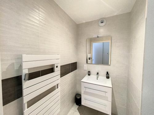 a white bathroom with a sink and a mirror at L oeillet Blanc - Maison familiale in Quiberon