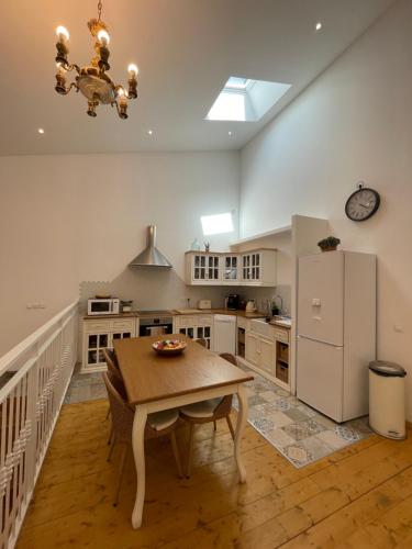 une cuisine avec une table et un réfrigérateur blanc dans l'établissement Appartement standing proche plage, à Fitou