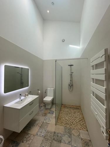 une salle de bain blanche avec un lavabo et des toilettes dans l'établissement Appartement standing proche plage, à Fitou