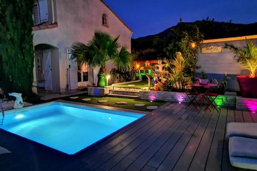 une piscine dans un jardin la nuit dans l'établissement A nice villa with pool and spa, cool garden!, à Laroque-des-Albères