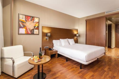 a hotel room with a bed and a chair at AZZ Valencia Congress Hotel & Spa in Paterna