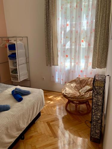 a room with two beds and a chair and a window at Dob street cute condo in Budapest