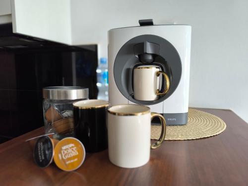 a coffee maker with two coffee cups on a counter at Downtown Apartment in Warsaw