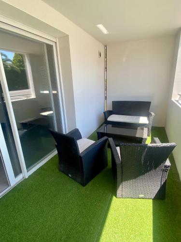 Cette chambre comprend des chaises, une table et un tapis vert. dans l'établissement Capbreton - Appt NEUF - 4 pers - 2 ch, à Capbreton