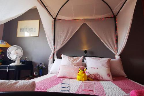 une chambre avec un lit à baldaquin avec un canard en caoutchouc dessus dans l'établissement A nice villa with pool and spa, cool garden!, à Laroque-des-Albères