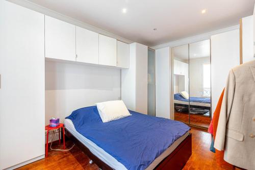 une chambre avec un lit bleu et un miroir dans l'établissement GuestReady - Bright stay next to The Eiffel Tower, à Paris
