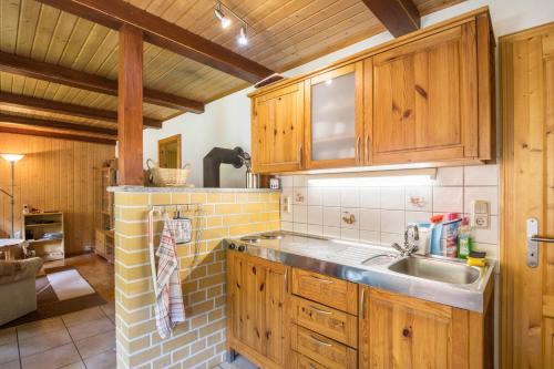 a kitchen with wooden cabinets and a sink at Ferienhaus Lausekuppe Neustadt in Neustadt/Harz