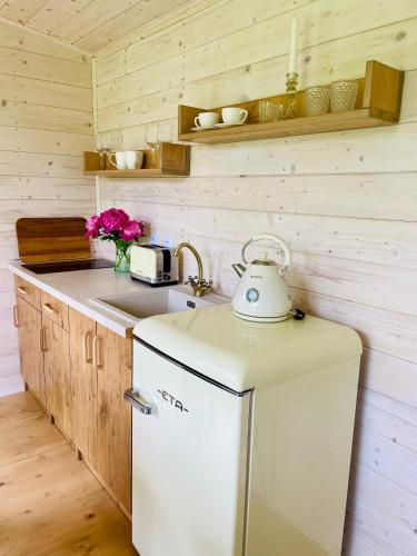 a kitchen with a white refrigerator and a sink at Sakura Tiny house in National park,salty pool in Staré Křečany