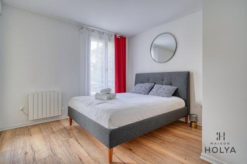 une chambre avec un lit et une fenêtre avec des rideaux rouges dans l'établissement Le Curieux - À deux pas de Paris - 314B, à Rueil-Malmaison