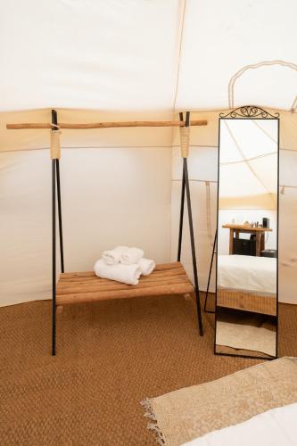 a room with a bed and a mirror and a bench at Rom Farm by Glow - חוות רום in Kammon