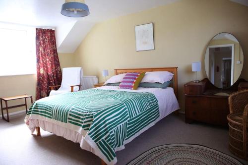ein Schlafzimmer mit einem großen Bett und einem Spiegel in der Unterkunft Convenient and stylish cottage in Abergavenny