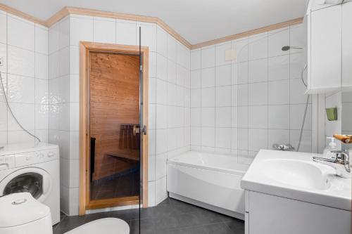 a bathroom with a tub and a toilet and a sink at Voss Resort self-catered apartments in Skulestadmo