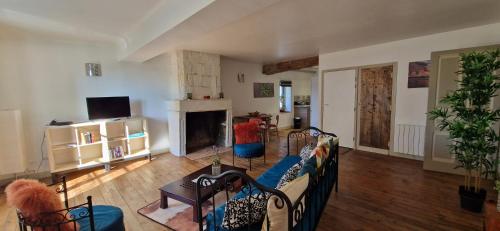 a living room with a couch and a fireplace at La Campinoise in Champigny-sur-Veude