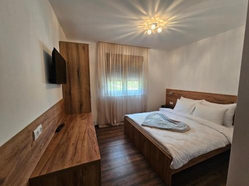 a bedroom with a bed and a television in it at Hostel PREMIUM in Derventa