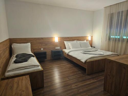a hotel room with two beds and a window at Hostel PREMIUM in Derventa