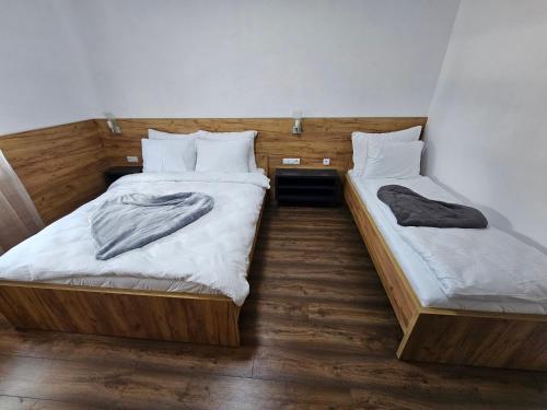 two twin beds in a room with wooden floors at Hostel PREMIUM in Derventa