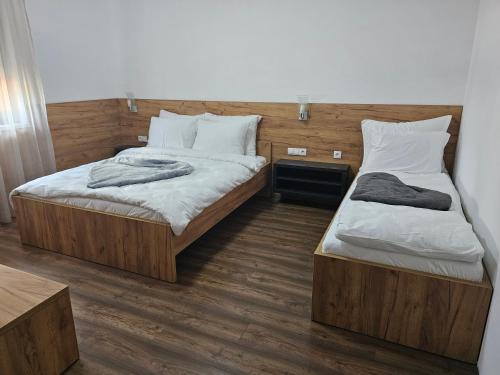 two beds in a room with wooden floors at Hostel PREMIUM in Derventa