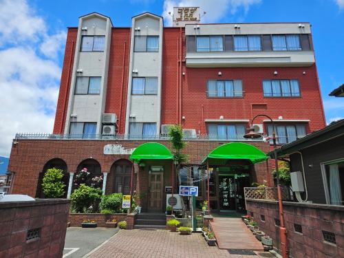 a building with green umbrellas in front of it at Plaza Inn Kawaguchiko in Fujikawaguchiko